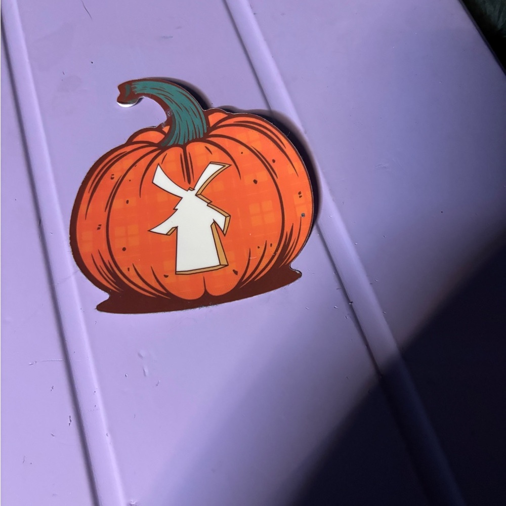 Dutch Bros Orange Pumpkin Sticker on Purple Surface